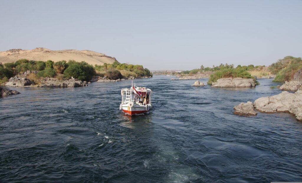 A striking aerial view of the Aswan High Dam, with the mighty Nile River flowing through the landscape